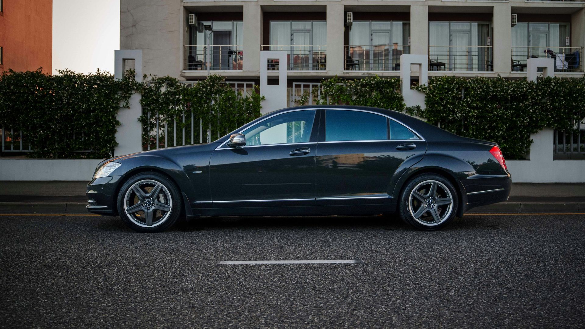 A dark grey luxury sedan parked on the street