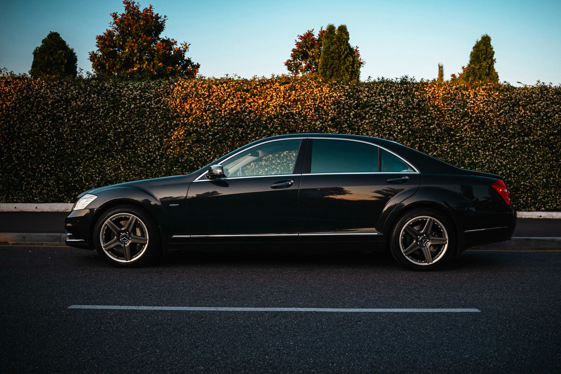 A black luxury sedan parked on the roadside